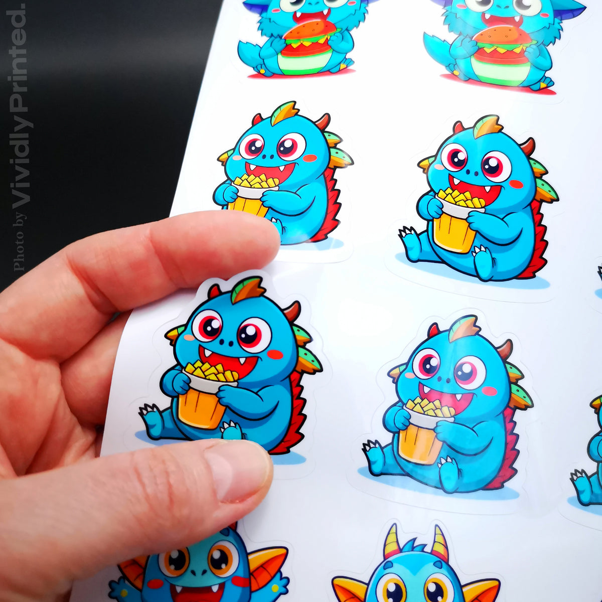 Peeling a blue dragon holding a drink from a sticker sheet