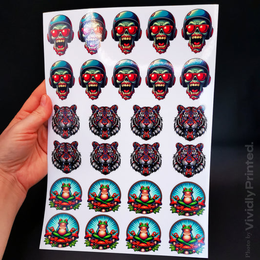 A hand holding a sticker sheet with skull, tiger and clown designs