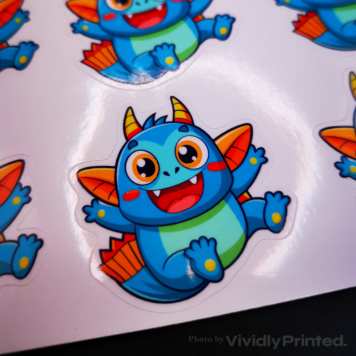 Close-up of a blue dragon sticker on a white backing sheet