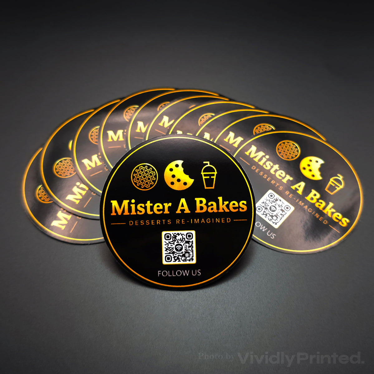 Round black and gold Mister A Bakes stickers with a QR code