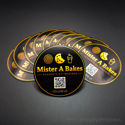 Round black and gold Mister A Bakes stickers with a QR code