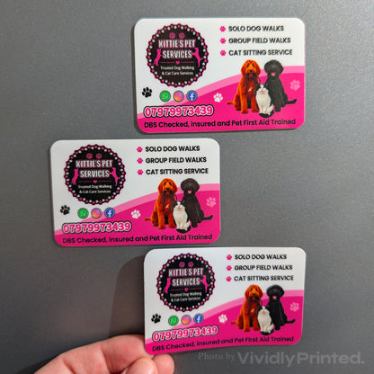 Pink pet service magnetic business cards displayed on a grey surface