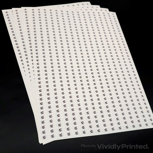 A stack of white sticker sheets with small repeated black logos